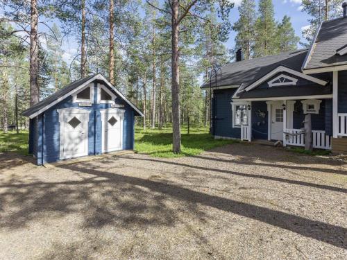 uma casa com uma garagem azul e branca em Holiday Home Komsikko b by Interhome em Äkäslompolo