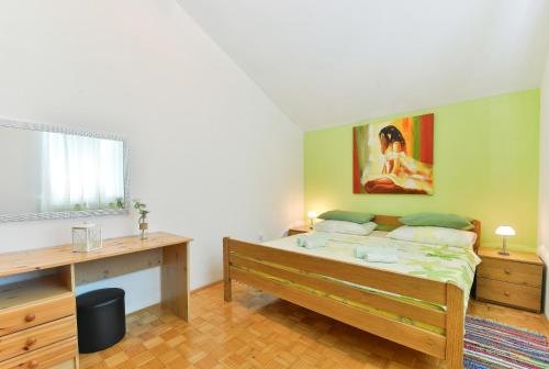 ein Schlafzimmer mit einem Bett und einem Schreibtisch mit einem Gemälde in der Unterkunft Apartments Crno in Zadar
