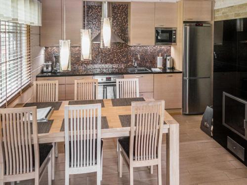a kitchen with a table and chairs and a refrigerator at Holiday Home Villa illi by Interhome in Tahkovuori