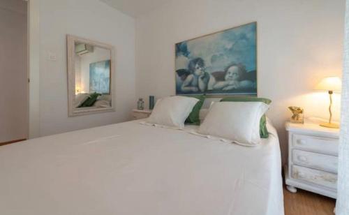 グラナダにあるApartamento Catedral centro ciudadの白いベッドルーム(大きな白いベッド1台、ドレッサー付)