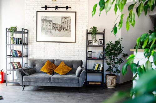 a living room with a gray couch with yellow pillows at Отель Art Gallery in Odesa