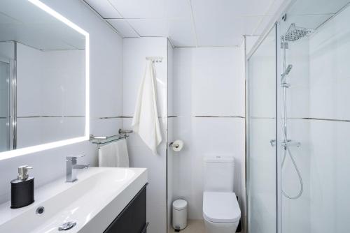 y baño blanco con lavabo y ducha. en Arcos Beach Infostays - Free Parking, en Málaga