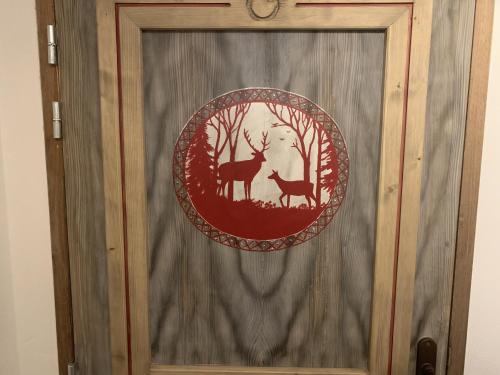 a wooden door with a picture of deer and trees at Les 7 laux immobilier chalet F in Prapoutel