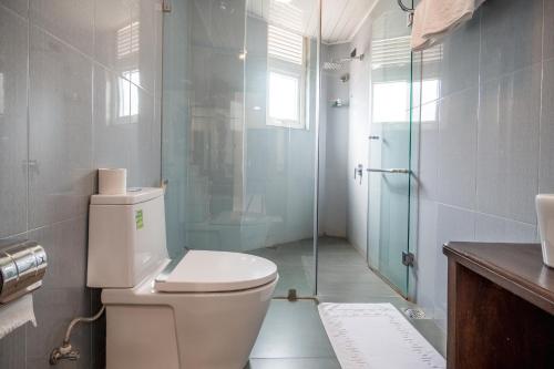 a bathroom with a toilet and a glass shower at Janora Hills in Kandy