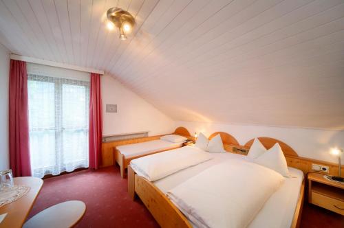 a hotel room with two beds and a window at Hotel Unterrain in Appiano sulla Strada del Vino