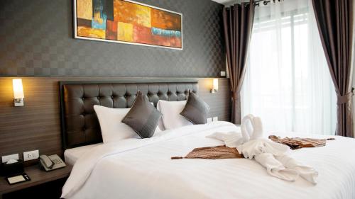 a hotel room with two beds with white sheets at Picnic Hotel Bangkok - Rang Nam in Bangkok