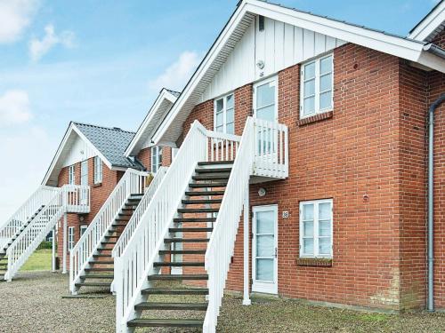 un edificio de ladrillo con escaleras en el costado en 4 person holiday home in R m en Rømø Kirkeby