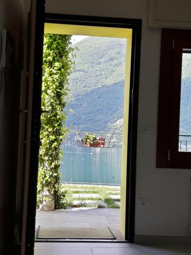 eine offene Tür mit Blick auf das Wasser in der Unterkunft Balcone dei Limoni in Nesso