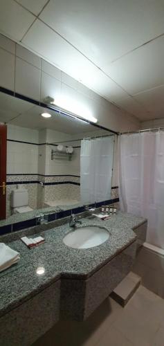 ein Bad mit einem Waschbecken und einem Spiegel in der Unterkunft Ivory Hotel Apartments in Abu Dhabi