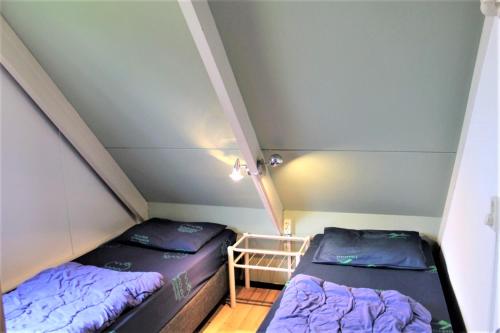 two beds in a small room with a attic at 6-pers vakantiebungalow in het Heuvelland in Simpelveld