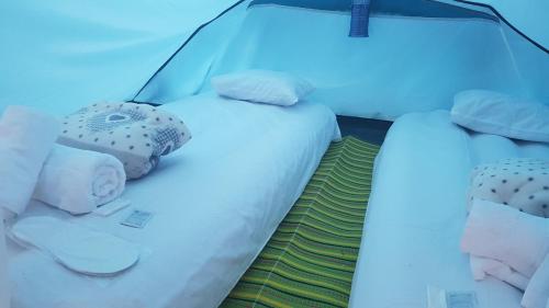 2 Betten in einem Zimmer mit blauem Licht in der Unterkunft Camp'in Goris in Goris