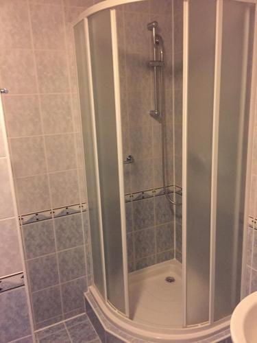 W łazience znajduje się prysznic ze szklanymi drzwiami. w obiekcie Tatra Hotel w Popradzie