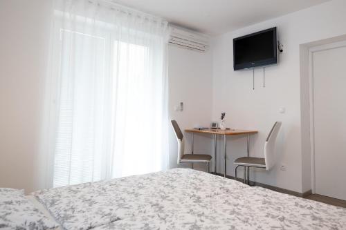 una camera con letto e tavolo con sedie di Sobe Meta a Brezje