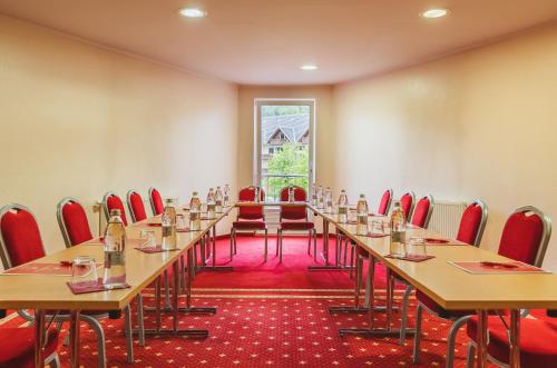 a room with a long table and chairs in it at Ramada Hotel & Suites Kranjska Gora in Kranjska Gora
