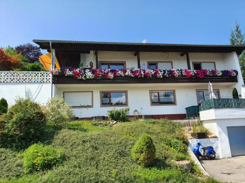 a house with flowers on the top of it at Ferienwohnung Gipfelblick in Oberreute