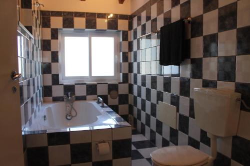 a bathroom with a tub and a toilet and a window at Villa Alegria - A Private, Cozy Retreat in Nature in Lagos