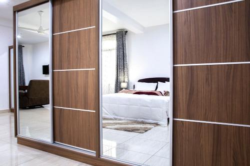 a bedroom with a wooden closet with a mirror at Two Mountains Lodge in Arusha