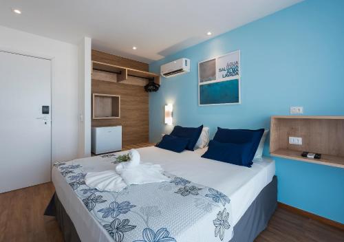 a bedroom with a large bed with blue walls at Pousada Olho D'água in Maragogi