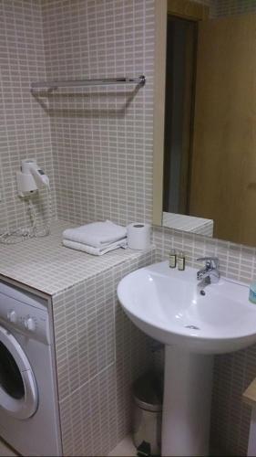 a white bathroom with a sink and a mirror at Apartamentos Laurel in Logroño