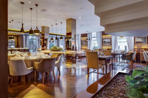 un comedor con mesas y sillas en un restaurante en Kuster Hotel, en Guarapuava