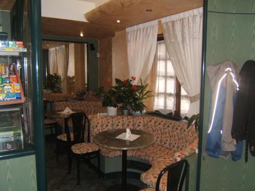 a restaurant with a couch and a table and chairs at Hotel Berlinghera in Sorico