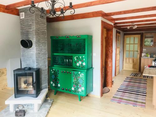 a green cabinet in a living room with a fireplace at Willa Anna in Kościelisko