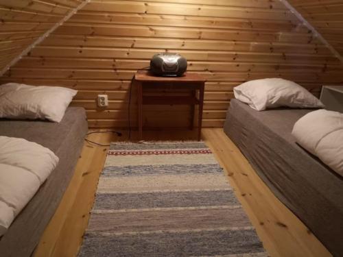 a room with two beds in a log cabin at Unikt läge med stora Alvaret som närmsta granne in Mörbylånga