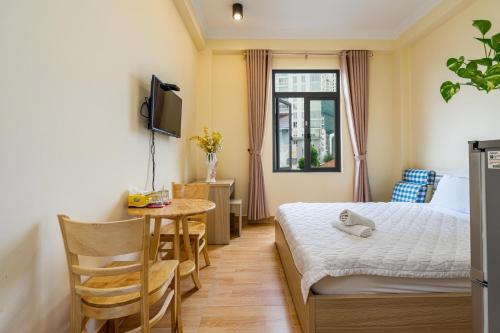 a bedroom with a bed and a table and a window at Maison Royale in Ho Chi Minh City