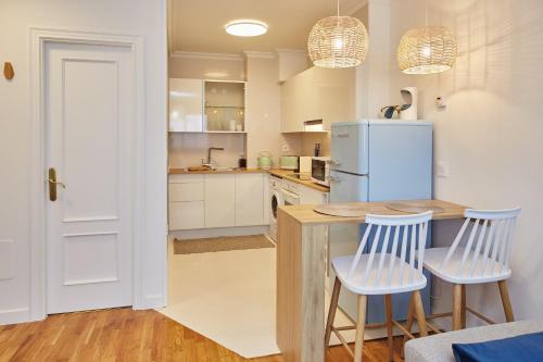 uma cozinha com uma mesa, 2 cadeiras e um frigorífico em Estudio nuevo centro de Vigo em Vigo