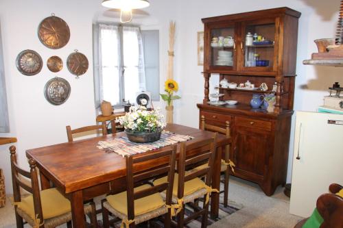 a dining room with a wooden table and chairs at Palazzo Vertemate Traona in Traona