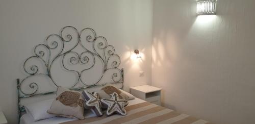 a bed with a large white headboard in a bedroom at Residence Porto Rotondo in Porto Rotondo