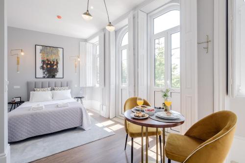 a bedroom with a bed and a table with chairs at Plaza-Charming GuestHouse in Porto