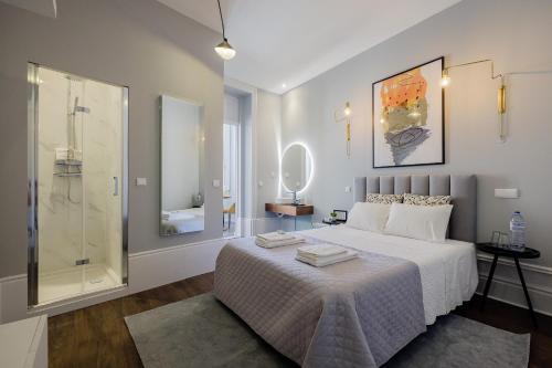 a bedroom with a large white bed and a shower at Plaza-Charming GuestHouse in Porto