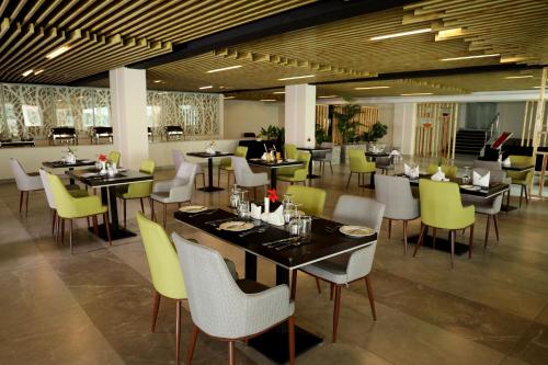 a dining room with tables and yellow chairs at PrideInn Plaza Nairobi Airport in Nairobi