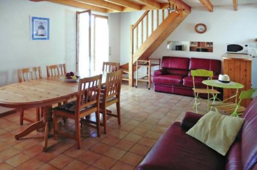 een woonkamer met een tafel en een bank bij Le clos de la Plage - Villa vintage avec jardin privatif- 500m de la plage - 6 personnes in Dolus d'Oléron