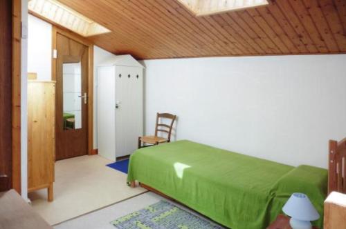 a bedroom with a green bed and a wooden ceiling at Le clos de la Plage - Villa vintage avec jardin privatif- 500m de la plage - 6 personnes in Dolus d'Oléron
