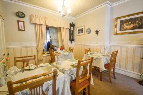 un comedor con mesas y sillas y una ventana en Gorphwysfa House B & B en Betws-y-coed
