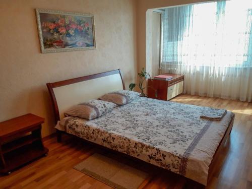 ein Schlafzimmer mit einem Bett in einem Zimmer mit einem Fenster in der Unterkunft Apartment on Livoberezna metro station in Kiew