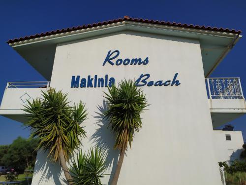 a sign on the side of a building with palm trees at Makinia Beach in Nafpaktos