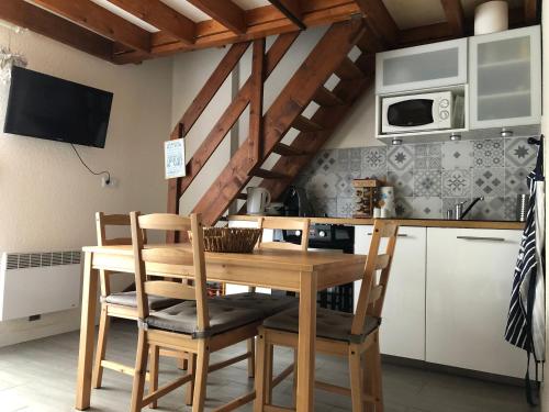 une cuisine avec une table et des chaises en bois dans l'établissement Cottage à Cabourg, à Cabourg