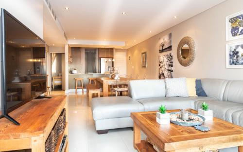 a living room with a couch and a table at Luxury Ocean View 2 Bed Apartment 259 Eden on the Bay, Blouberg, Cape Town in Big Bay