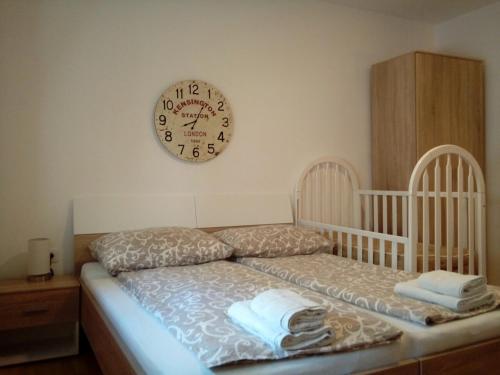 尼什的住宿－Kuća Popović Apartments，卧室配有婴儿床和墙上的时钟