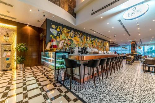 a bar in a restaurant with a checkered floor at First Central Hotel Suites in Dubai