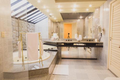 uma casa de banho com uma banheira e um lavatório e uma banheira em Hotel Atlantico Star no Rio de Janeiro