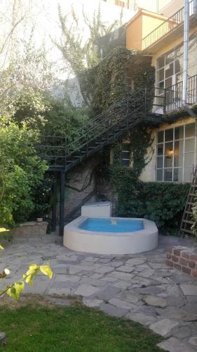 a building with a swimming pool in front of a building at Alamo Hostel & Suites in Mendoza