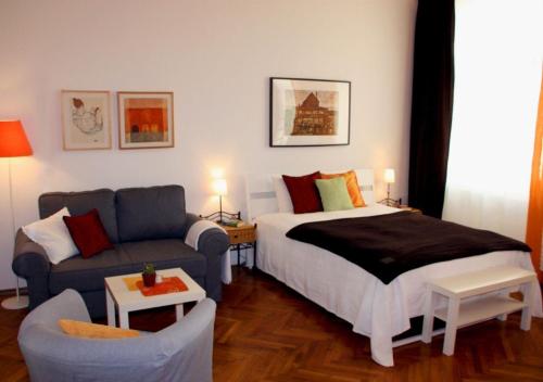 Habitación de hotel con cama y sofá en Cosy Appartement close to City, en Viena