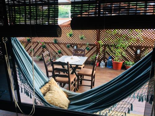 a hammock in a patio with a table and chairs at Shiva Guest House in Florianópolis