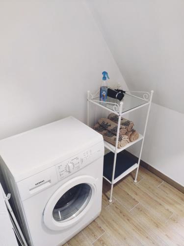 a white washing machine in a room with a shelf at Old Slabada Apartments in Kaunas