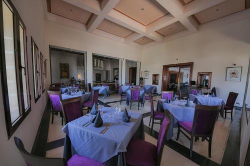 a dining room with blue tables and purple chairs at Hôtel Des Iles in Essaouira