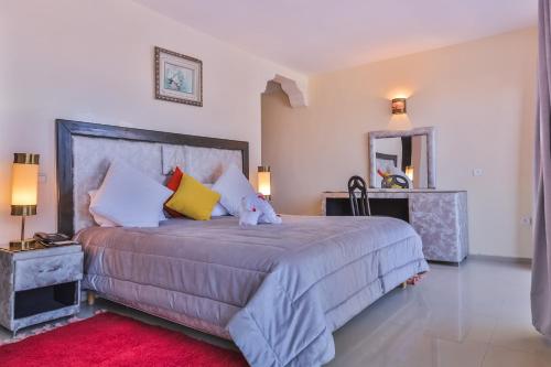 a bedroom with a large bed and a mirror at Hôtel Des Iles in Essaouira